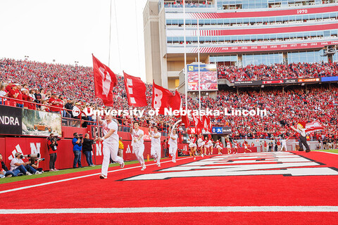 The Nebraska Spirit Squad runs along the end zone with flags that spell out Nebraska after a touchdo