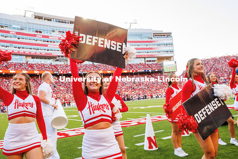 Spirit Squad member, Grace Nab, holds up a sign that says “Defense” during the Nebraska vs Akron