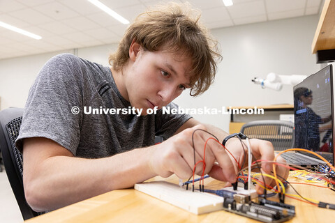 Ian Gouldie, sophomore, robotics engineering major, connects wires to properly run a program to turn