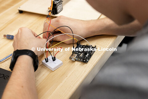 Ian Gouldie, sophomore, robotics engineering major, connects wires to a circuit board in order to ru
