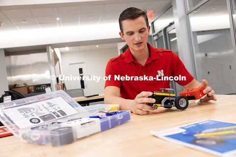 Patrick Stolinski, junior, shows a prototype of a transmission tractor robotics kit inside the Kiewi