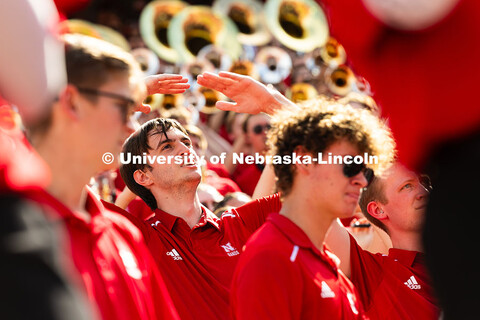 Hayden Giannini, a junior and member of the marching band pit, lifts his hands to form an "O" as the