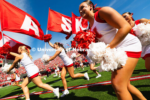 Cheerleaders lead the way as the Husker football team runs onto the field before facing Houston Chri