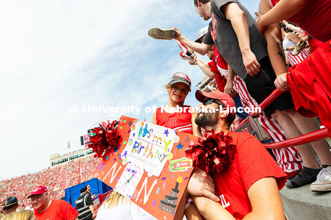 Chris Pelster lifts his daughter, Eden, as they wait for the Scarlets the take to the field. Eden tu