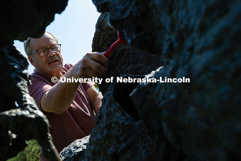 Les Bruning, owner of Bruning Sculpture in Omaha, uses a brush to remove dust and debris from Ruben 