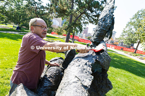 Les Bruning, owner of Bruning Sculpture in Omaha, uses a brush to remove dust and debris from Ruben 