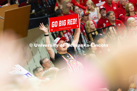 Jacob Gill, a sophomore studying secondary education, holds up a sign that reads "Go Big Red!" durin