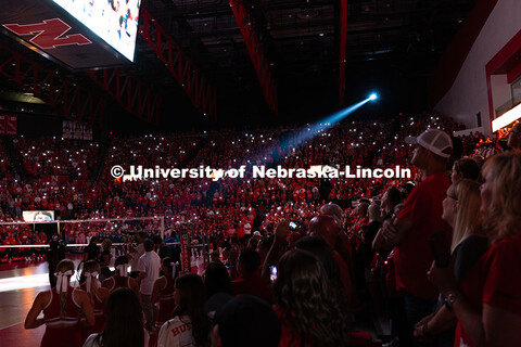 A spotlight shines onto the volleyball court during a pregame video before the game against the Univ