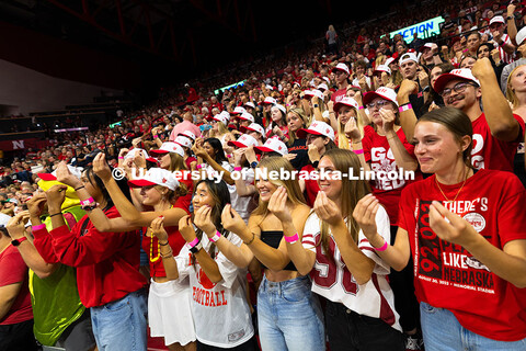 Students hold their hands up with their fingers to their thumb for Virginia Adriano, a Husker first-