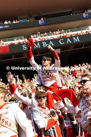 Band members hoist Shane Daughtrey, a senior vocal performance major, for the Simba cam during the g