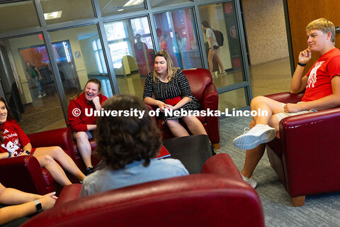 Students chat outside of the Honors Program staff offices with Sawyer Smith (in black dress), coordi