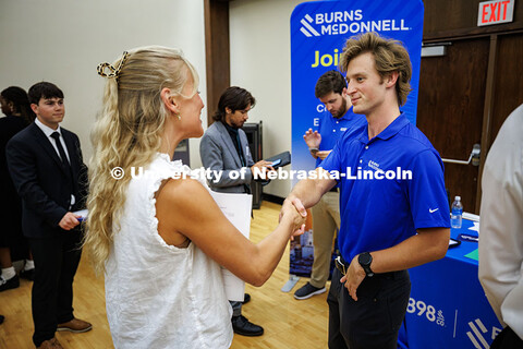 Mechanical Engineering major, Teagan Little, shakes hands with a Burns McDonnell representative duri
