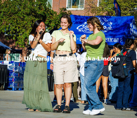 Mariana Hernandez-Moreno, a music education major from Omaha, sings while dancing with some Fiesta o
