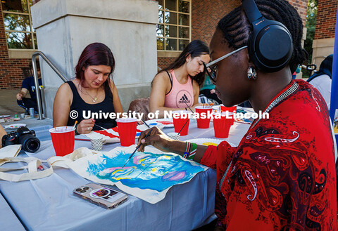 A student paints a tote bag during the Fiesta on the Green festivities. Fiesta on the Green is an an