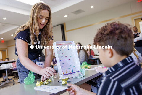 Molly Vickery, left, senior management major, presents her vitamin dispenser to the judges inside Ho