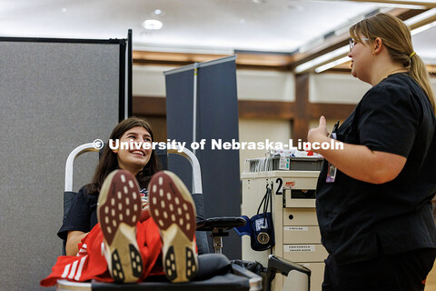Elle Klanderman, a senior Sports Media and Communication/Broadcasting major, chats with a worker fro
