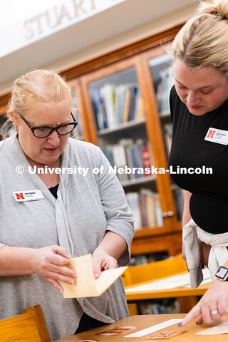 Casey Coleman (left) and Sophie Kowalski, who both work in the Office of Graduate Studies, look thro