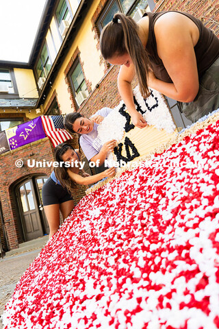 Kappa Delta members Maddie Balus, Jordan Tipton and Ella Reifenrath glue pom-poms made from party na