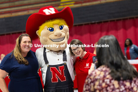 Angela Rushing (left) and Karen Bentz (right) pose for a photo at the photo booth with Herbie Husker