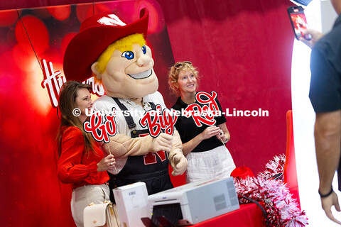 Carmen Kelle and Kristin Plath pose for a photo with Herbie Husker at the photo booth during the Cel