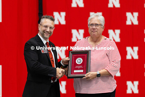 Susan Budler poses for a photo with Ben Lennander after receiving a plaque recognizing her 45 years 