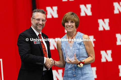 Larita Lang poses with Ben Lennander after receiving a vase recognizing her 45 years of service to t