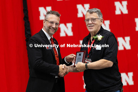 Donald Puckett poses for a photo with Ben Lennander after receiving a plaque celebrating his 50 year