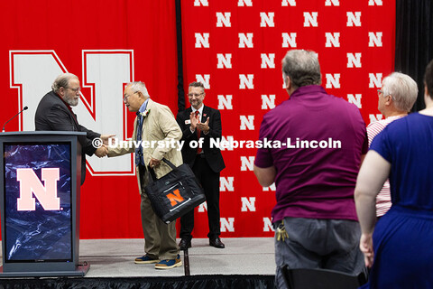 Bing Chen shakes hands with Rick Alloway during the Celebration of Service. Both were recognized dur