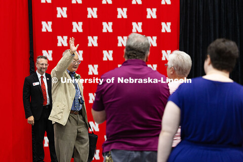 Bing Chen waves to the crowd after receiving a standing ovation for serving 60 years with the univer