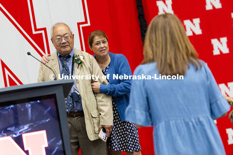 Bing Chen poses for a photo with his wife on the stage at the Celebration of Service event, where he