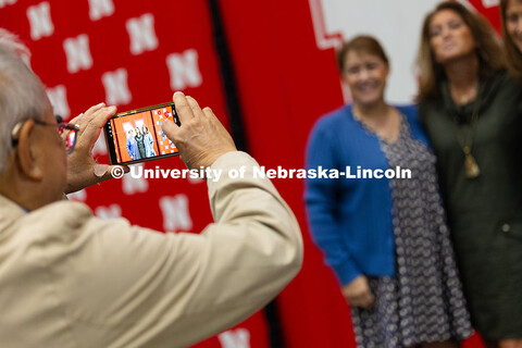 Bing Chen snaps a photo of his wife and her sisters on the stage after the Celebration of Service. C