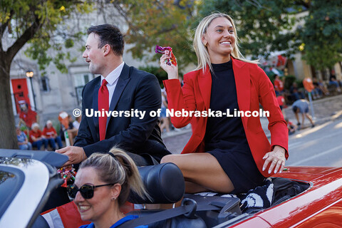Homecoming royalty Ava Hollingsworth tosses candy to spectators as she rides in a vintage car during