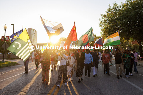 International Students carry their flags as they march along R street during the homecoming parade. 