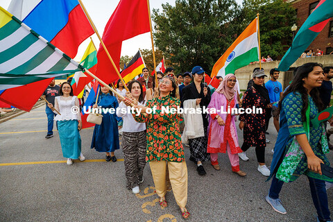 International students wave their flags as they walk in the 2025 Homecoming parade. Homecoming parad