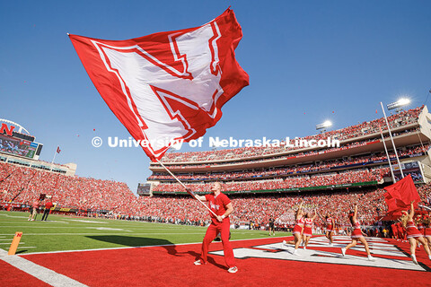 A Nebraska Spirit Squad member waves the giant N flag after the Huskers scored a touchdown. Nebraska