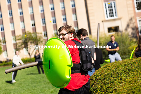 Reed Strasburg peeks over the edge of his "shield" during a mock battle between the Spartans and Ath