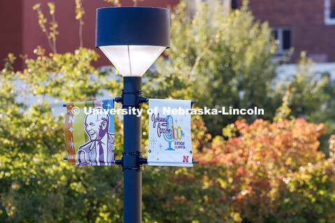 Signs celebrating University of Nebraska alum Johnny Carson’s 100th birthday hang from light poles