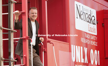 Dr. Shane Farritor poses on a caboose custom painted and donated to the University of Nebraska–Lin