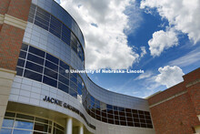 A blue sky and clouds reflect off the front of the Jackie Gaughan Muluticultural Center. Campus Beau