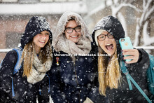 Kayla Felix, left, and Alli Hauger smile as Emily Hames takes a selfie of them while they walked to 