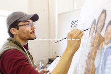 Luis Martinez works on his project in Aaron Holz's intermediate/advanced painting class. March 28, 2