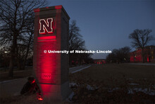 Seth Carne of TMS installs lights on the East Campus gateway / entrance columns for Glow Big Red. Gl