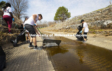 Alec Skinner pulls debris from Deadman's Run as teams worked to clean up trash in the run east of Ea