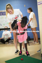 Emma Hastings watches an elementary student at the putting game as she and others from Gamma Phi Bet