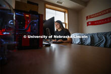 Young woman studying on her computer in her Kauffman Academic Residential Center dorm room. Raikes s