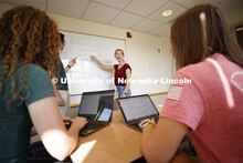 Students studying in a classroom, working through a problem on the marker board. Raikes school photo