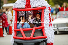 Triad 4's golf cart rolls along the parade route. Triad 4's members are Phi Kappa Psi, Delta Gamma, 