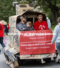 Lorelai Dingman, 2, shares a ride with Marine veterans and second year students Rodrigo Venegas, lef