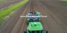 Brandi Sigmon and Christine Smith pours a packet of seeds into the hopper as the tractor slowly trav