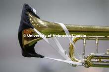 Band members have used ingenuity to cover their horn's bell. Cornhusker Marching Band practice in Co
